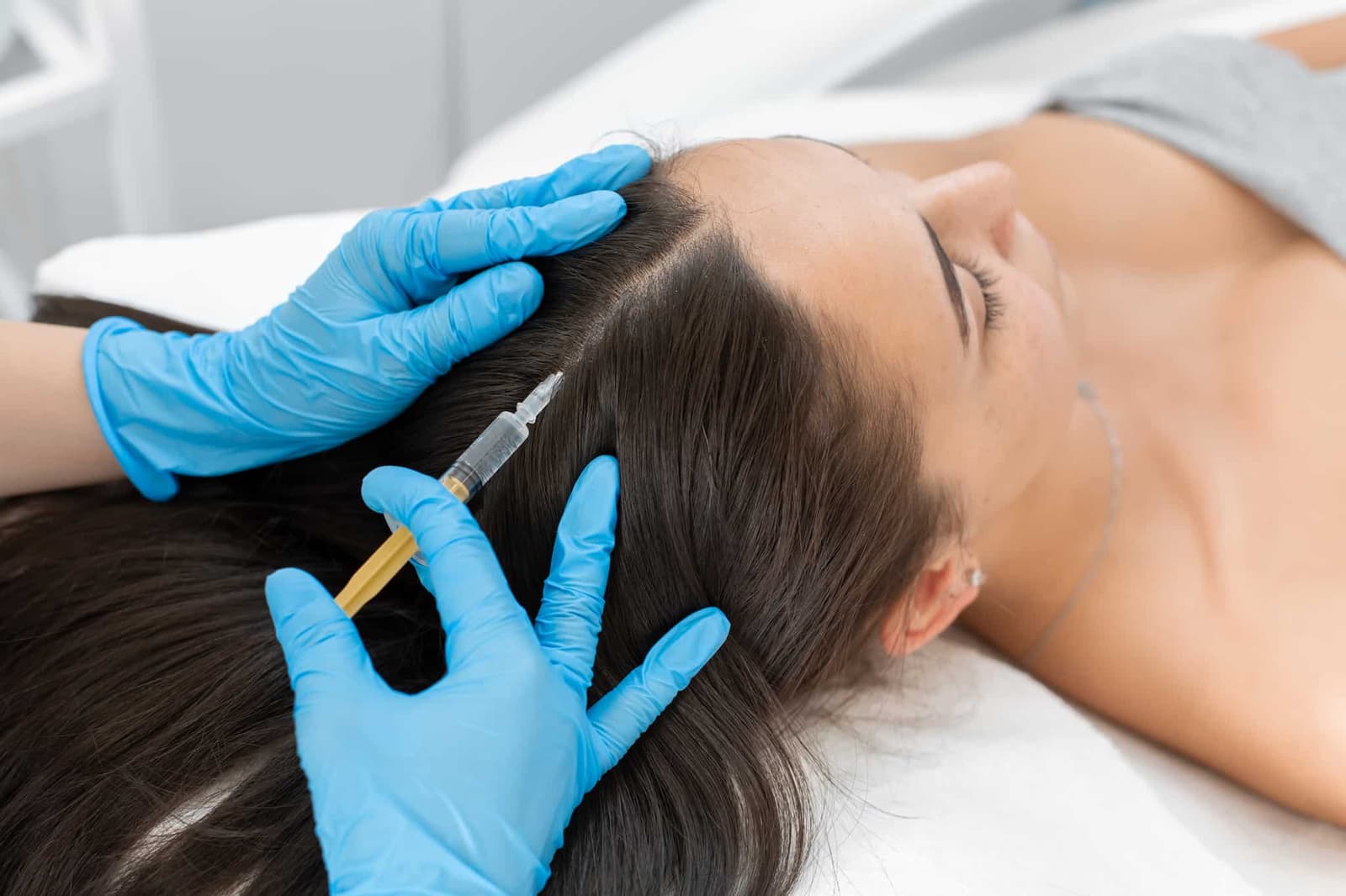 A patient is receiving a PRP injection in their scalp.